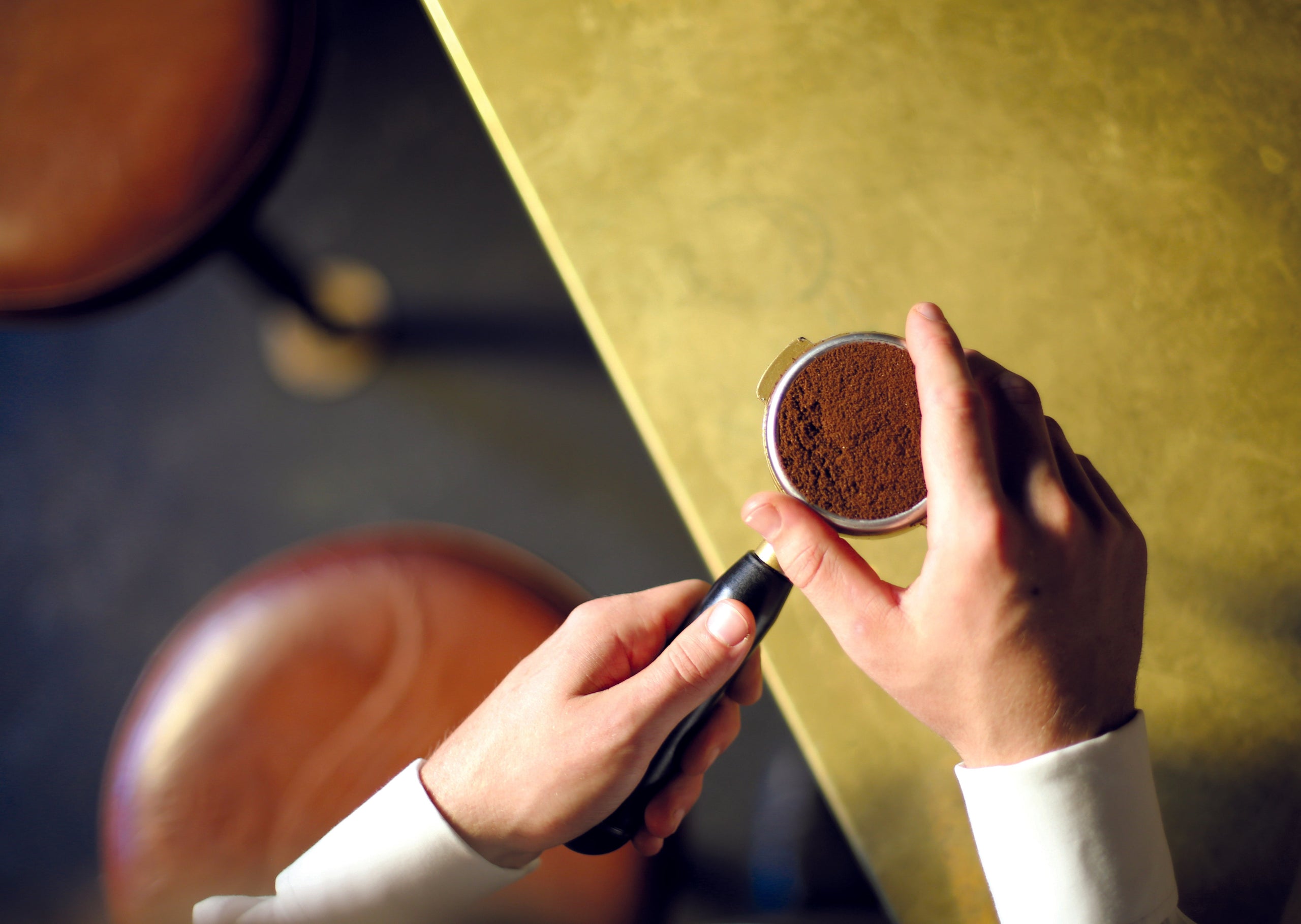 A barista preparing a to make a macchiato coffee